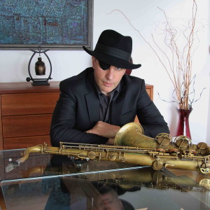 A man sitting at a table with a saxophone.