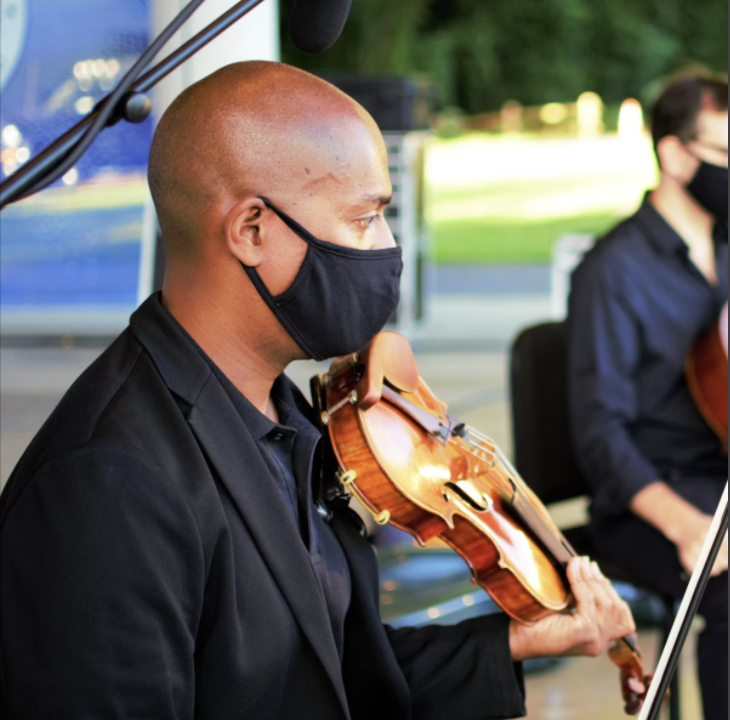 A man wearing a mask playing the violin.